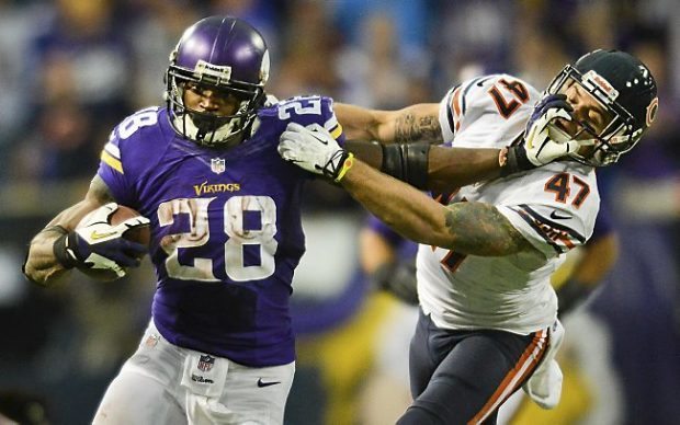 Vikings running back Adrian Peterson takes the ball for 21 yards as he stiff arms Bears free safety Chris Conte in overtime. Peterson ran for 211 yards on 35 carries, and broke the 10,000-yard career rushing mark.   (Pioneer Press: Ben Garvin)