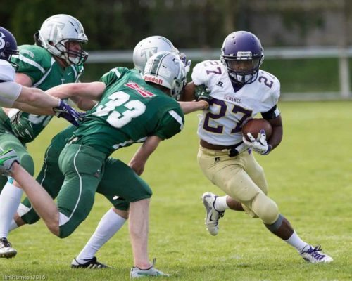 Running-Back Ronald Hayes Jr. evading Trojan defenders